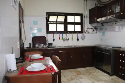 a kitchen with a table and a kitchen with a stove at Suites Pinto Coelho in Caniço