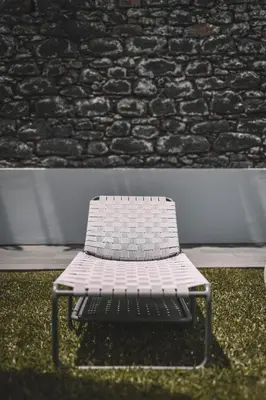 a white bench sitting in front of a brick wall at QUINTA TORRINHA GARDEN Apartment in Funchal