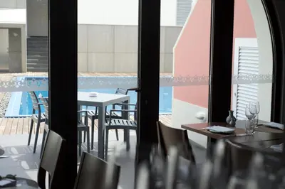 a room with a table and chairs and a pool at Charming Blue in Vila do Porto