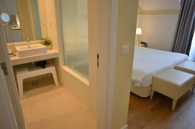 a bathroom with a bed and a sink in a room at Charming Blue in Vila do Porto
