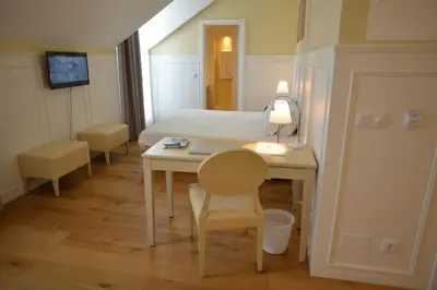 a room with a bed and a desk with a table at Charming Blue in Vila do Porto