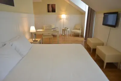 a bedroom with a bed and a desk with a laptop at Charming Blue in Vila do Porto