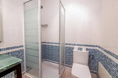a bathroom with a toilet and a glass shower at Casa Palmeira in Lagos