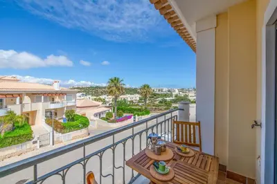 a balcony with a table and a view of a building at Casa Palmeira in Lagos
