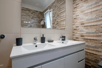 a bathroom with two sinks and a mirror at Caniço Quintas III by Trip2Portugal in Caniço