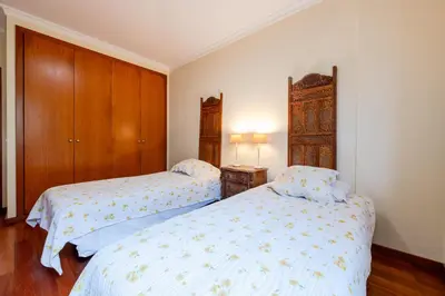 a bedroom with two beds and a wooden cabinet at Caniço Quintas III by Trip2Portugal in Caniço