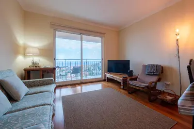 a living room with a couch and a large window at Caniço Quintas III by Trip2Portugal in Caniço