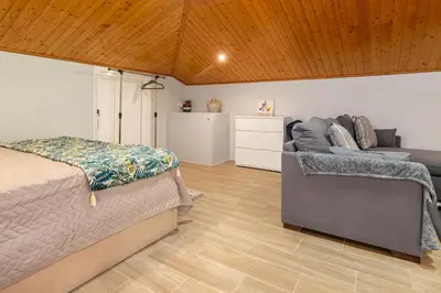 a bedroom with a bed and a couch at Casa Miradouro do Pigarro, Sunny Apartment in Calheta