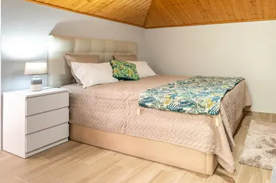 a bedroom with a bed and a nightstand with a bed sidx sidx at Casa Miradouro do Pigarro, Sunny Apartment in Calheta