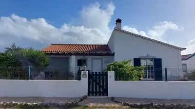 a church yard with chairs and a table and a cross at Villa Atlantico in Aljezur
