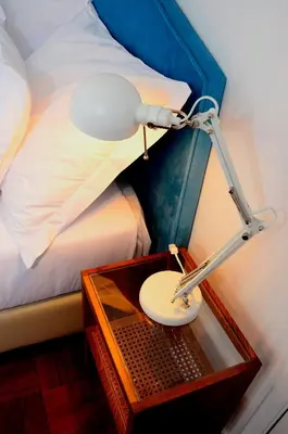 a lamp on a table next to a bed at VILA ALEGRIA in Funchal