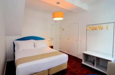 a bedroom with a large bed with a blue headboard at VILA ALEGRIA in Funchal