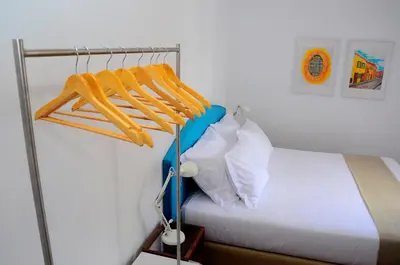 a bedroom with a bed and a rack with towels at VILA ALEGRIA in Funchal