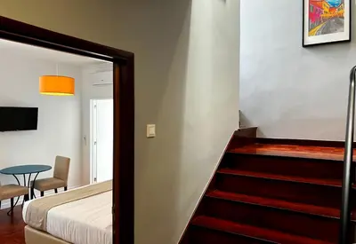 a bedroom with a staircase leading up to a bed at VILA ALEGRIA in Funchal