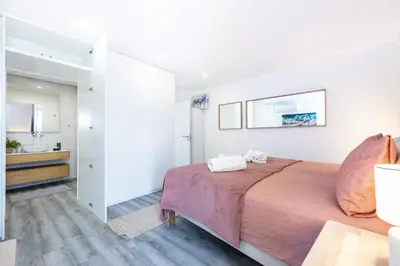 a street with white buildings with tables and chairs at Frontline Seaview Apartment in Budens
