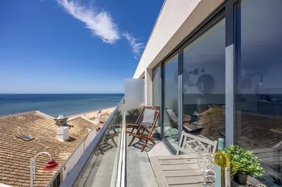 a living room with a blue couch and a table at Frontline Seaview Apartment in Budens