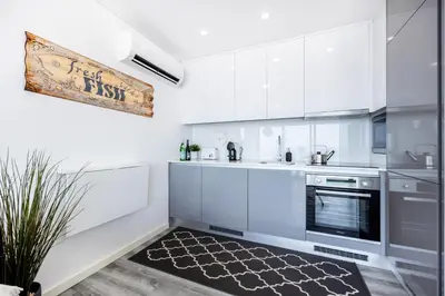 a mirror in a room with a bed and a sink at Frontline Seaview Apartment in Budens