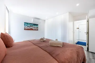 a bedroom with a large bed with a brown blanket at Frontline Seaview Apartment in Budens