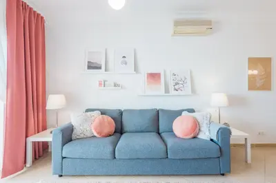 a blue couch with pink pillows in a living room at Boavista Charming Apartment in Lagos