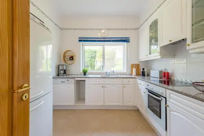 a kitchen with white cabinets and a window at Boavista Charming Apartment in Lagos