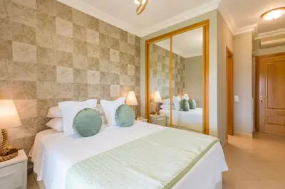 a bedroom with a large white bed and a mirror at Boavista Charming Apartment in Lagos