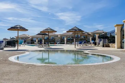 a small pool with umbrellas and tables and chairs at Boavista Charming Apartment in Lagos