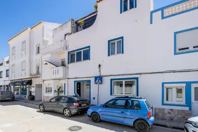 two cars parked in front of a white building at Casa Jana 5 Bedroom House for 12 with Ocean View Terrace near the Beach in Burgau