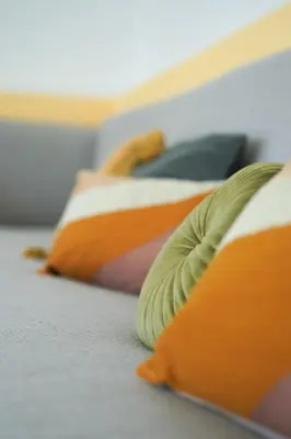 a bed with orange and green pillows on it at Birds of Paradise - Boutique Surf Lodge in Aljezur