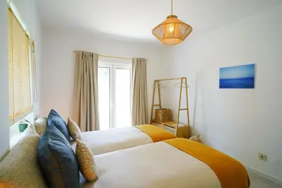 a bedroom with two beds and a window at Birds of Paradise - Boutique Surf Lodge in Aljezur