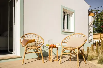 two chairs and a table on a patio at Birds of Paradise - Boutique Surf Lodge in Aljezur