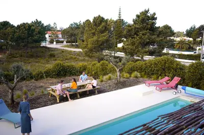 a rendering of people sitting on a bench by a pool at Birds of Paradise - Boutique Surf Lodge in Aljezur