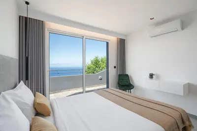 a bedroom with a bed and a large window at Intelsol Calheta Apartments by An Island Apart in Calheta