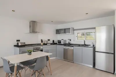 a kitchen with stainless steel appliances and a table at Intelsol Calheta Apartments by An Island Apart in Calheta