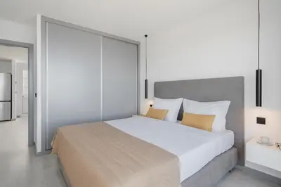 a bedroom with a large white bed with pillows at Intelsol Calheta Apartments by An Island Apart in Calheta