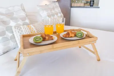 a wooden table with two glasses of orange juice and pastries at Madeira Ocean View by Atlantic Holiday in Caniço