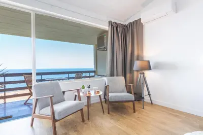 a living room with a table and chairs and a balcony at Madeira Ocean View by Atlantic Holiday in Caniço