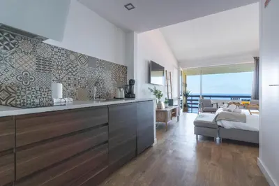 a kitchen with a sink and a living room with a bed at Madeira Ocean View by Atlantic Holiday in Caniço