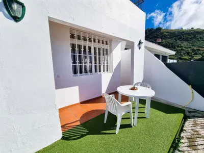 a small white table and chairs on a balcony at Casa Torbit, Apartment in Arco da Calheta in Arco da Calheta
