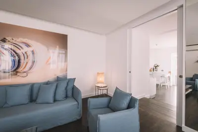 a living room with a blue couch and a painting on the wall at QUINTA TORRINHA LUXODREAM Apartment in Funchal