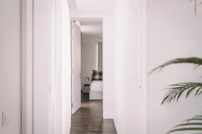 a hallway with white walls and a bed in a room at QUINTA TORRINHA LUXODREAM Apartment in Funchal