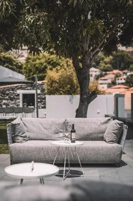 a couch and a table with a bottle of wine on it at QUINTA TORRINHA LUXODREAM Apartment in Funchal