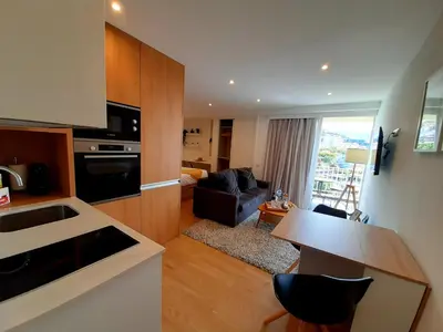 a kitchen and living room with a table and a couch at Superb Sea View Flat in Funchal in Funchal