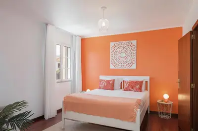 a bedroom with a bed with an orange wall at Vila Boa Vista by An Island Apart in Funchal