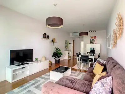 a living room with a couch and a tv at Alameda Apartment by LovelyStay in Funchal