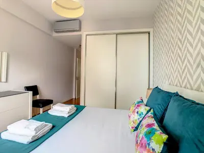 a bedroom with a white bed with blue pillows at Alameda Apartment by LovelyStay in Funchal