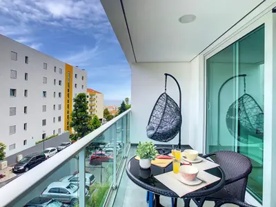 a balcony with a table and chairs and a view of a city at Alameda Apartment by LovelyStay in Funchal
