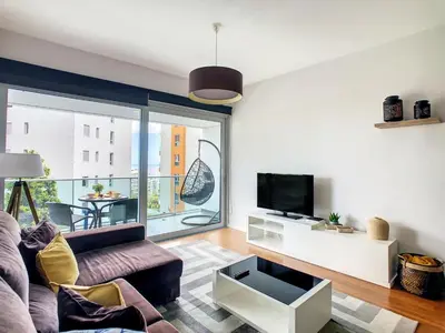 a living room with a couch and a tv at Alameda Apartment by LovelyStay in Funchal