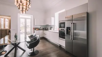 a kitchen with a glass table and a stainless steel refrigerator at QUINTA TORRINHA PANORAMA Apartment in Funchal