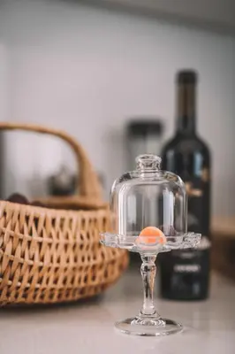 a glass dish with an orange in it next to a bottle of wine at QUINTA TORRINHA PANORAMA Apartment in Funchal