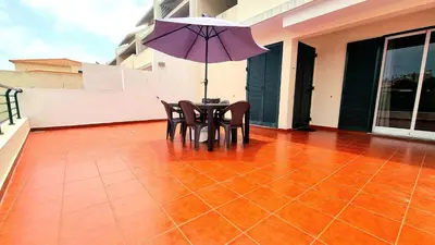 a table and chairs on a balcony with an umbrella at Casa Gouveia in Porto Santo